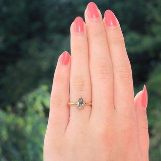 Salt and pepper diamond engagement ring worn on hand outdoors.