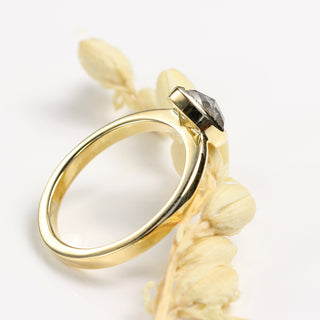 Angled view of pear cut salt and pepper diamond engagement ring showing milgrain detail.