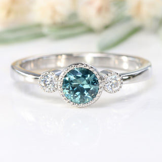 Front view of teal blue sapphire and diamond trilogy engagement ring, handmade from solid 950 platiinum.